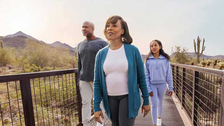 Actor portrayal of TUKYSA (tucatinib) patient and loved ones walking down a pathway outdoors.
