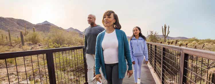 Actor portrayal of TUKYSA (tucatinib) patient and loved ones walking down a pathway outdoors.